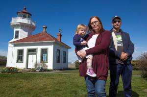 Andy Bronson / The Herald                                 Mukilteo Lighthouse Festival Association President Julie Martin, holding her granddaughter, Ariah Martin, 2, and Bashar Elali, vice president. Martin says the festival could use help. We still have a large chunk of last years festival to pay off, so were working on coming up with some fundraisers.