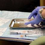 In this Feb. 13 photo, a health care worker prepares syringes, including a vaccine for measles, mumps, and rubella (MMR), for a childs inoculations at the International Community Health Services in Seattle. (AP Photo/Elaine Thompson, File)