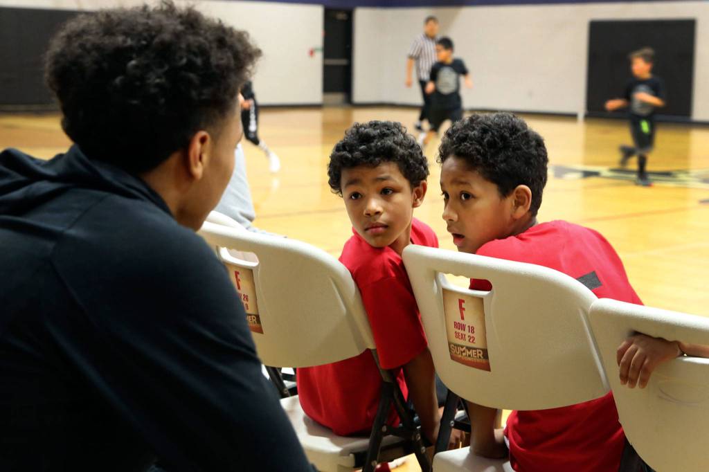 RaeQuan Battle (left) talks with JJ Gray and Tayari Williams-Archibald at the Tulalip Boys & Girls Club in January. Battle, a proud Tulalip Tribes member, is believed to be the first from his tribe to receive a Division-I college basketball scholarship. (Kevin Clark / The Herald)
