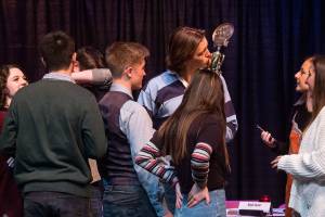 As his teammates celebrate their win, Jake Spores kisses a trophy after Stanwood High won the Hi-Q academic quiz competition championship held at Stanwood High School on Friday. Stanwood beat out Monroe and Archbishop Murphy for the win. (Andy Bronson / The Herald)
