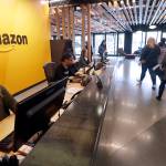 In this 2018 photo, employees walk through a lobby at Amazons headquarters in Seattle. (AP Photo/Elaine Thompson, File)