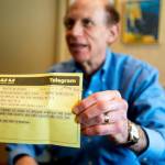In a March 1 photo, Robert Fink holds up a telegram from a family friend congratulating him on his 1969 graduation from the University of Michigan at his home in Huntington Woods, Michigan. (Jacob Hamilton/Ann Arbor News via AP)