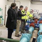 Coupeville Mayor Molly Hughes, Naval Air Station Whidbey Island commander Capt. Matt Arny and town Utility Superintendent Joe Grogan discuss how a new water filtration system will work with the existing process. (Laura Guido / Whidbey News-Times)