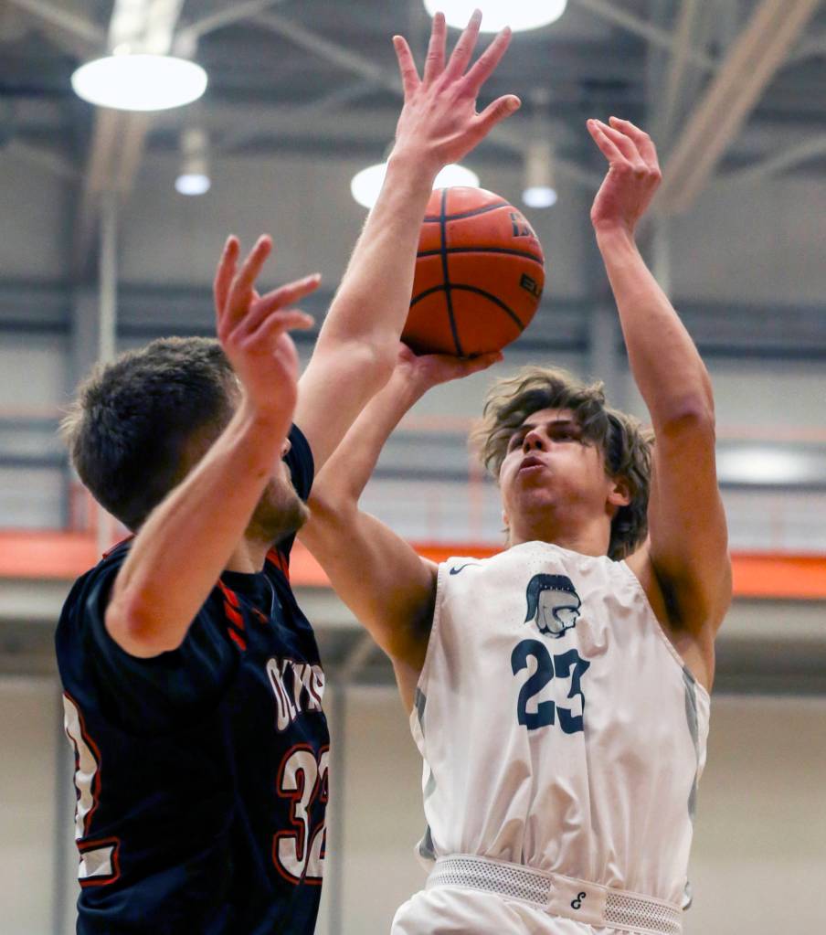 Everetts Magnus Jespersen (right) attempts a shot with Olympics Calvin Dennis defending at Everett Community College on Feb. 20 in Everett. (Kevin Clark / The Herald)