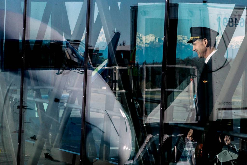 A pilot begins boarding a plane during the grand opening of Paine Field Airport on March 4 in Everett. (Olivia Vanni / The Herald)