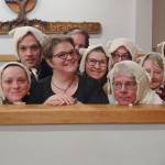 Director Jennifer Rodgers (center) is surrounded by members of the Everett Chorale dressed in one of the costumes they will wear at their March 30 concert. (Chase Dermott)