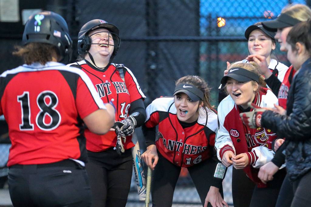 Snohomish players gather to celebrate a towering solo home run by Isabelle Hansen (18). The senior standout finished 3-for-4 with a homer, two doubles and four RBI. (Kevin Clark / The Herald)