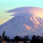 Lenticular clouds cap Mount Rainier at dusk as a jet passes by on Dec. 31, 2018, as seen from Seattle. (AP Photo/Elaine Thompson, file)