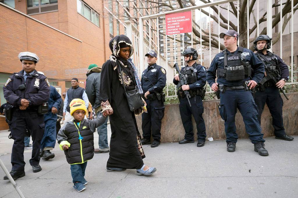 People leave the Islamic Cultural Center of New York under increased police security following the shooting in New Zealand on Friday in New York. (AP Photo/Mark Lennihan)