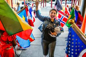 Senior Damilka Ortega runs past flag-waving students flanking the entryway to Cascade High School for Wednesdays first-ever Culture Night. She modeled a dress that she is carrying from Puerto Rico and recited her own poetry at the event. (Dan Bates / The Herald