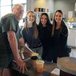 Maristas Coffee Shop owner Maria Kuehlthau and baristas Kristina Romero and Christina Gavrishov smile with one of their many regulars on their last day in operation. (Olivia Sullivan / Federal Way Mirror)
