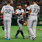 Seattles Ichiro Suzuki (center) greets teammates while leaving the field after being subsituted in the fourth inning of the Mariners 9-7 win over Oakland on Wednesday in Tokyo. (AP Photo/Toru Takahashi)