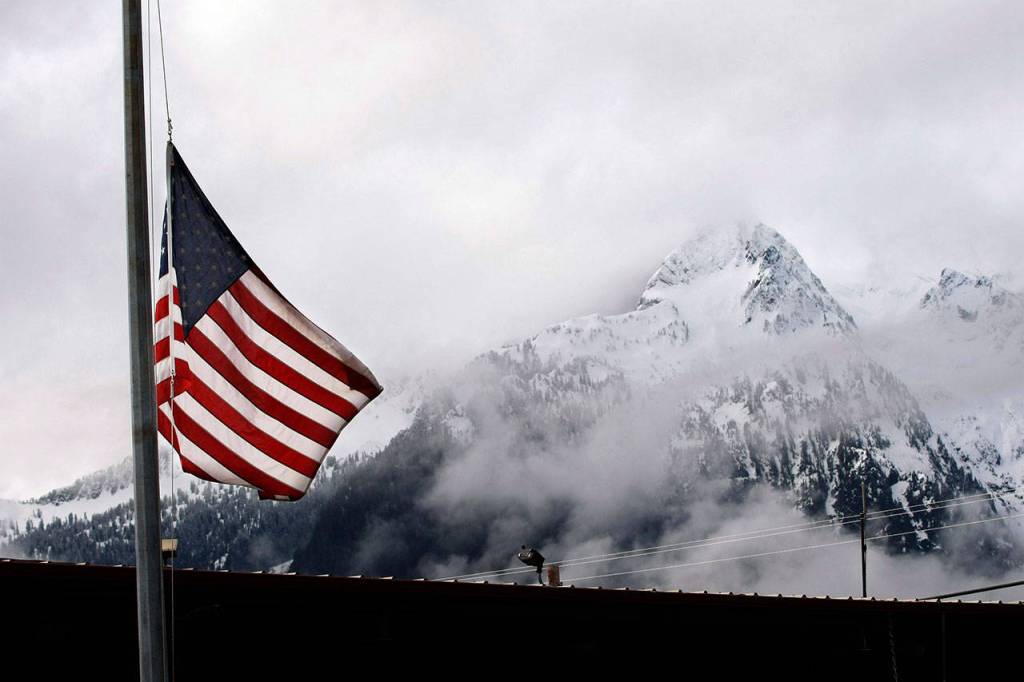 The flag flies at half mast in front of the Darrington fire station on March 26, 2014. (Genna Martin / The Herald)