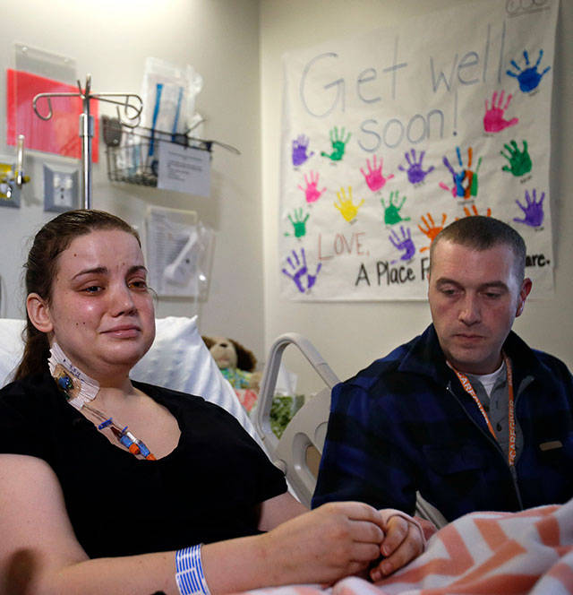Speaking from her hospital bed on April 9, 2014 with her partner Ty Suddarth, Amanda Skorjanc, 25, talks about surviving the Oso mudslide. (Dan Bates / The Herald)