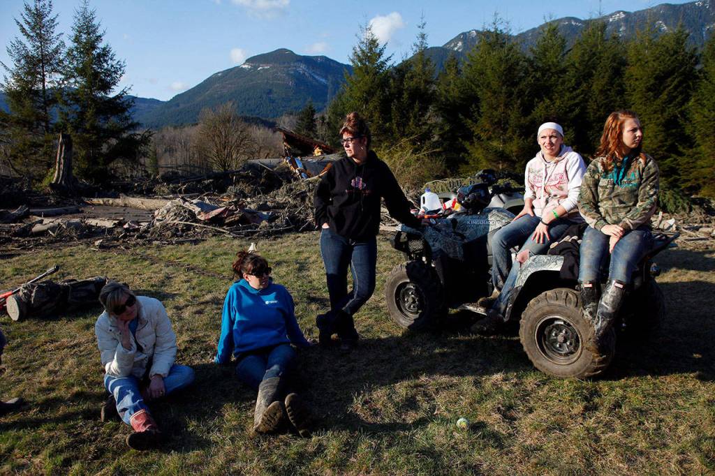 Friends and neighbors gathered at the Kuntz family property on March 23, 2014, where several bodies were found amidst the wreckage (Genna Martin / The Herald)