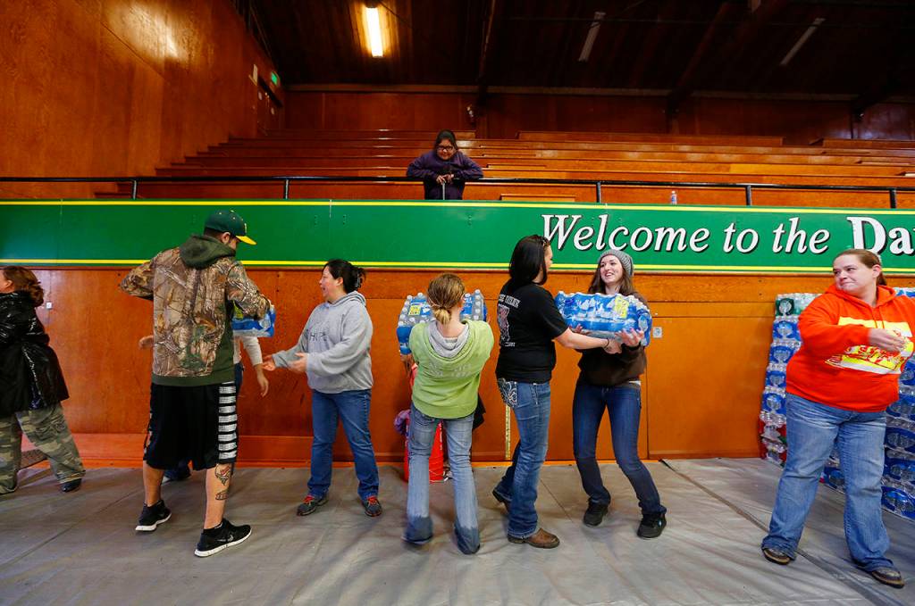 Volunteers help unload supplies inside the Darrington Community Center on March 29, 2014. (Annie Mulligan / For The Herald)
