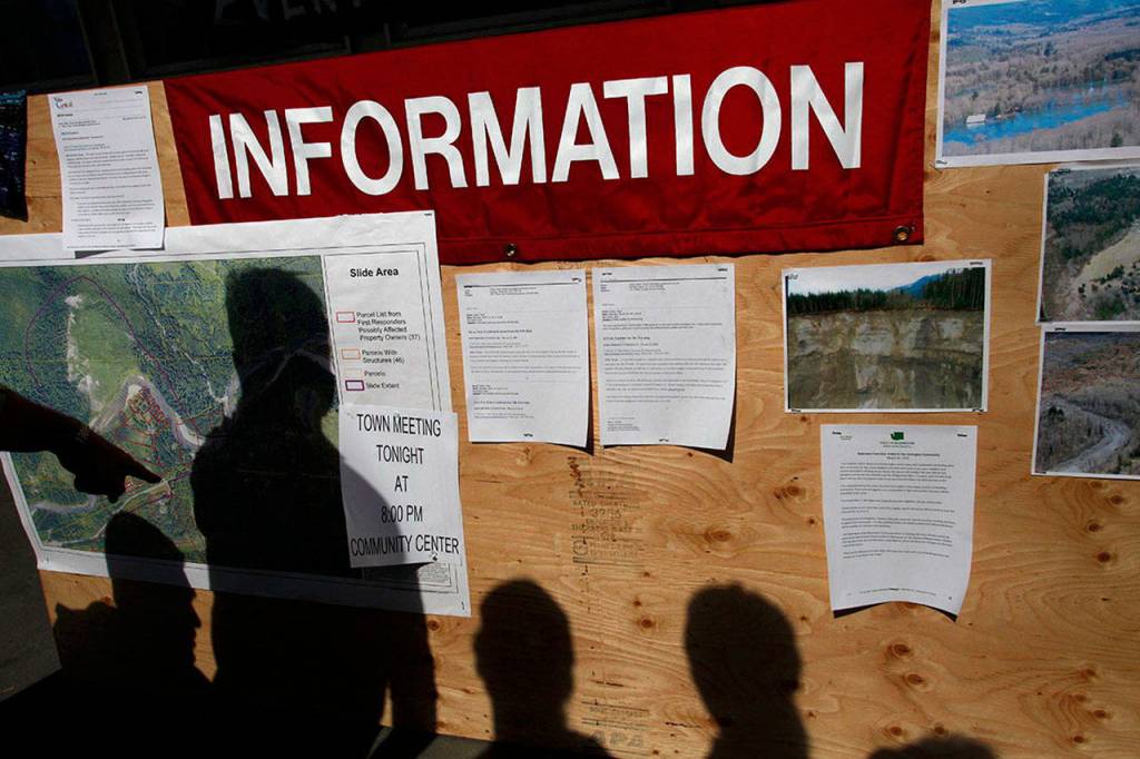 Community members check a map of the Oso mudslide area at the Darrington IGA market on March 24, 2014. (Sofia Jaramillo/ The Herald)