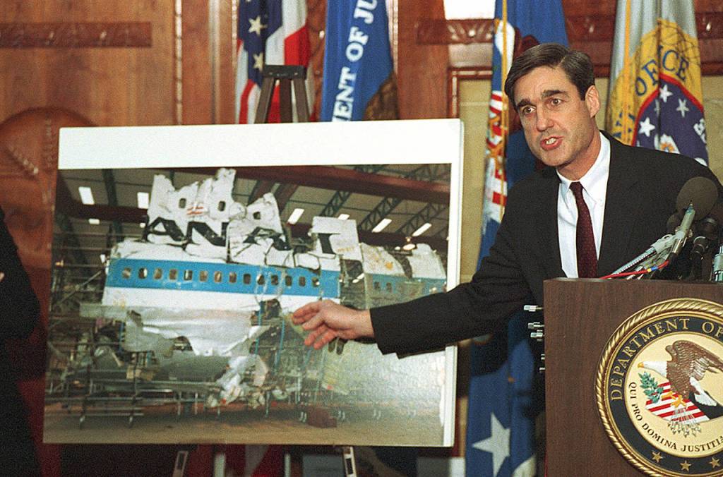 In this Nov. 14, 1991, photo, then-Assistant Attorney General Robert Mueller points to a photo of the reconstructed wreckage of Pan Am Flight 103, which exploded over Lockerbie Scotland in 1988, killing 270 people. (AP Photo/Barry Thumma, file)