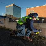 As a member of the Business Improvement Association crew, Cody McDougall cleans up multiple graffiti marks along a wall in downtown on March 18, 2019 in Everett. (Andy Bronson / The Herald)