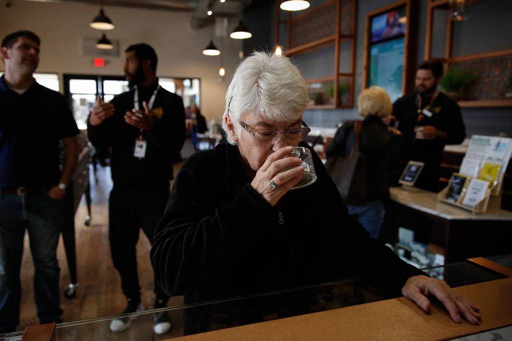 Sandy Sopher, 65, smells cannabis buds at Bud and Bloom cannabis dispensary in Santa Ana, California, on Feb. 19. (AP Photo/Jae C. Hong)