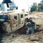 Staff Sgt. Travis Atkins stands in the crater from an improvised-bomb attack that he survived in Iraq. (U.S. Army)