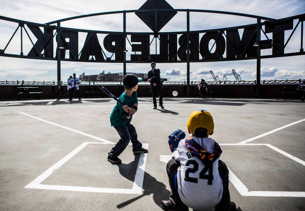 Mark Brandeberry pitches to his son Wake Brandeberry, 5, at the top level play field during Opening Day at T-Mobile Park on Thursday, March 28, 2019 in Seattle, Wash. (Olivia Vanni / The Herald)