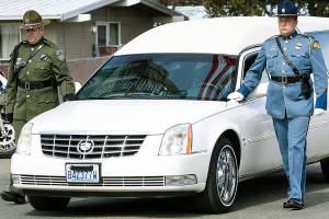 A hearse bearing the body of Kittitas County Deputy Sheriff Ryan Thompson arrives ahead of a memorial service Thursday at Central Washington University in Ellensburg. Hundreds of law enforcement officers from throughout the region have gathered for a memorial service for Thompson, who was shot to death by a road rage suspect last week. (Jake Green/The Daily Record via AP)