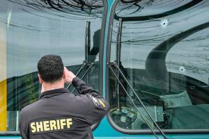Several bullet holes can be seen in the drivers side window of a Metro Bus on Northeast 125th Street, between 32nd and 33rd Avenues Northeast, after a shooting Wednesday in Seattle. (Dean Rutz/The Seattle Times via AP)