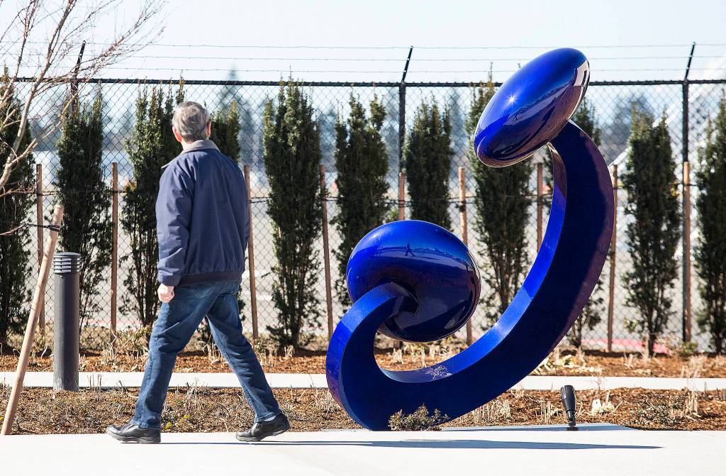 A man looks at the sculpture titled Aurora at the new terminal at Paine Field on March 18 in Everett. (Andy Bronson / The Herald)