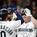 The Mariners Jay Bruce (right) smiles as he is greeted at the plate by Edwin Encarnacion (10) and Domingo Santana on after hitting a three-run, home run against the Red Sox on March 30, 2019, in Seattle. (AP Photo/Elaine Thompson)