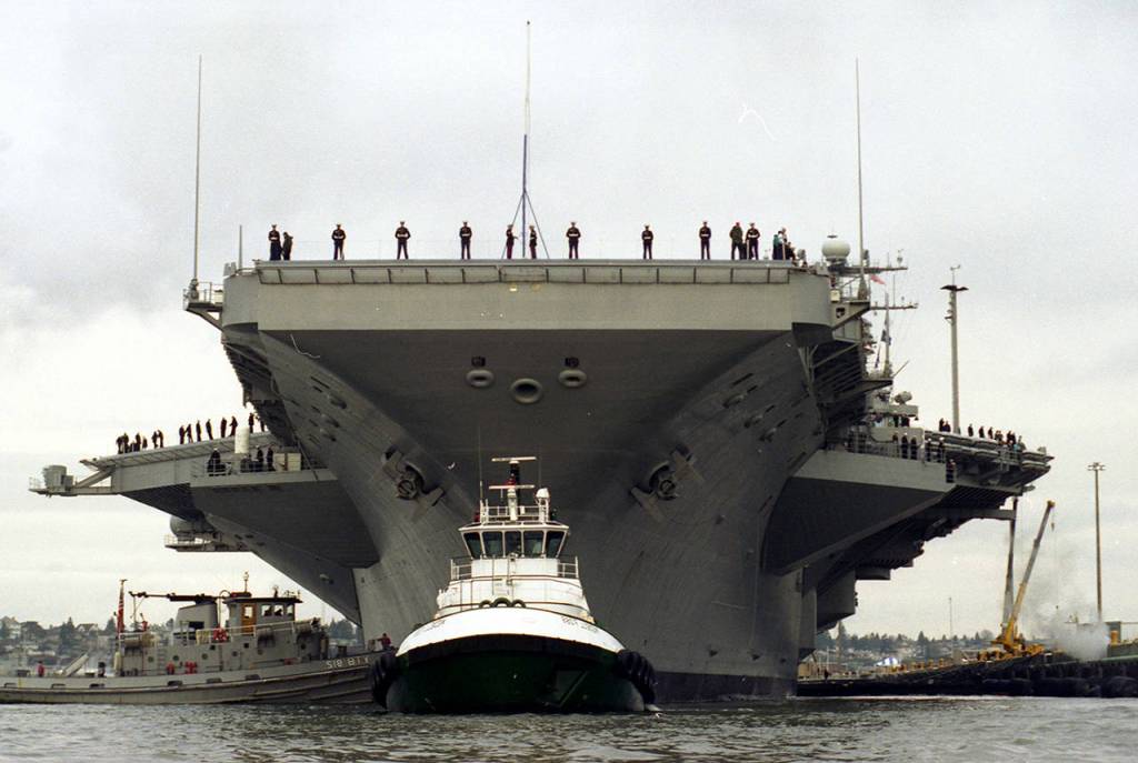 Guided by a tugboat, the USS Lincoln docks at Naval Station Everett for the first time on Jan. 8, 1997. (Dan Bates / Herald file)