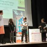 Nolan Walsh, playing the character Cigarette, Michael Usoltsev in the role of scientist, and Narinayse Vural, playing her character, a vaping device. (Brighton School)