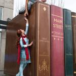 Silja Dos Reis and Jerome Sordillon pose with the books sculpture at the Everett Library. (Andy Bronson / The Herald)