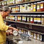 Debbie Thomas bags up fresh baking soda from the bulk bins at Central Market in Mill Creek on April 9. (Kevin Clark / The Herald)