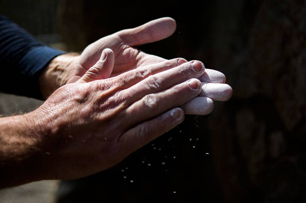 Smoot chalks up his hands before climbing at Schurman Rock at Camp Long on April 2 in Seattle. (Olivia Vanni / The Herald)