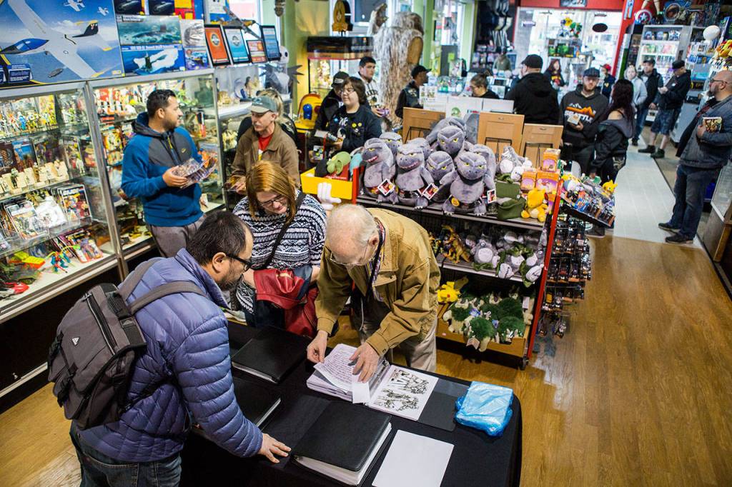 Roger Sweet, who helped design Mattels Masters of the Universe characters, signs memorabilia Saturday at BobaKhan Toys & Collectibles in Everett. (Olivia Vanni / The Herald)