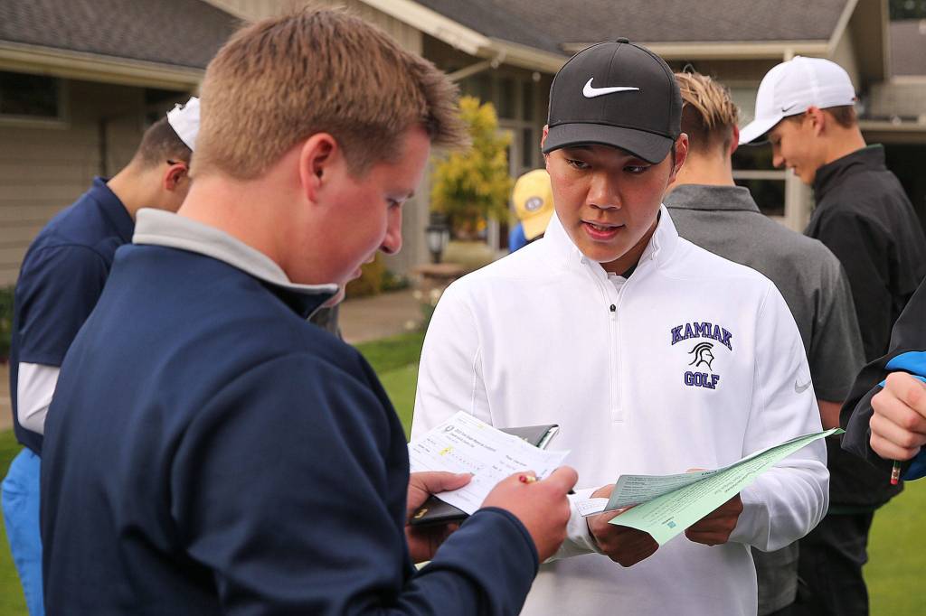 Everetts Andrew Martin (left) and Kamiaks Alvin Kwak work to total their scores during the Tom Dolan Memorial Invitational golf tournament Monday afternoon at Everett Golf & County Club in Everett on April 8, 2019. (Kevin Clark / The Herald)