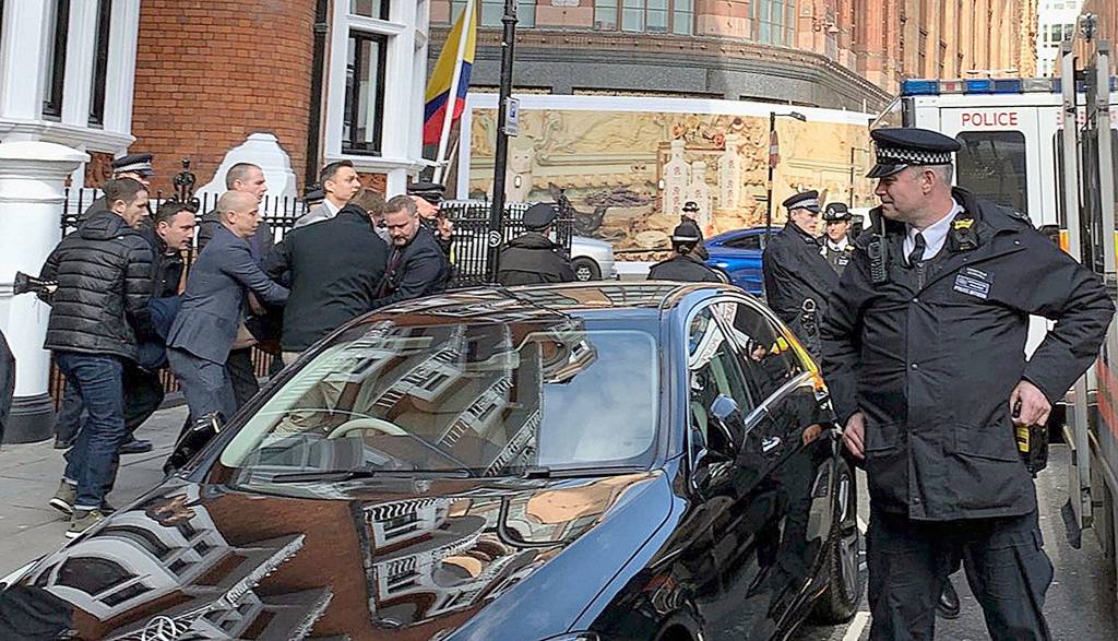 Police carry WikiLeaks founder Julian Assange from the Ecuadorian embassy in London after he was arrested Thursday. (@DailyDOOH/PA via AP)