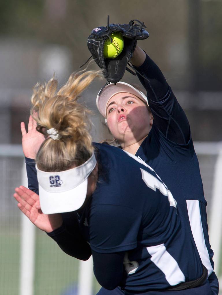 With bases loaded and two outs, Glacier Peaks Ashley Schmer makes the inning-ending catch over the head of teammate Phoebe Schultz as Glacier Peak beat Lake Stevens 6-3 in a fastpitch game on April 9 in Lake Stevens. (Andy Bronson / The Herald)