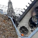 A man is pictured near chared glass windows Notre Dame cathedral on Tuesday in Paris. Firefighters declared success Tuesday in a more than 12-hour battle to extinguish an inferno engulfing Paris iconic Notre Dame cathedral that claimed its spire and roof, but spared its bell towers. (AP Photo/Francois Mori)