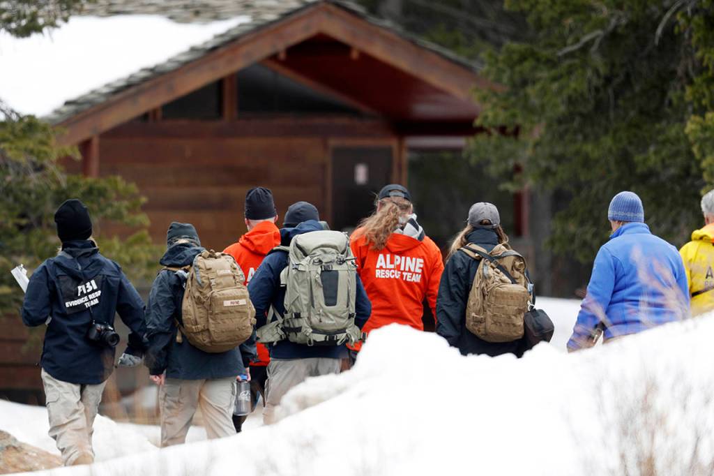 Investigators head into the forest along Mount Evans Road on Wednesday near Idaho Springs, Colorado, to search for a young Florida woman who authorities say was so infatuated with the Columbine school shooting they feared she was planning an attack in Colorado just days ahead of the 20th anniversary. (AP Photo/David Zalubowski)