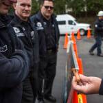 Everett Fire Department members look at the deep gash in a hot dog caused by an electrical arc during a demonstration Wednesday in Everett. (Olivia Vanni / The Herald)