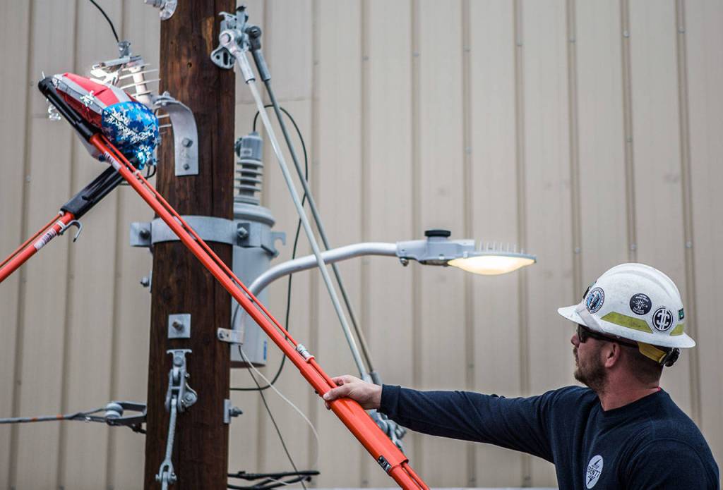 Jake Morgan shows how a mylar balloon can cause a transformer to break during the trailer demonstration Wednesday in Everett. (Olivia Vanni / The Herald)