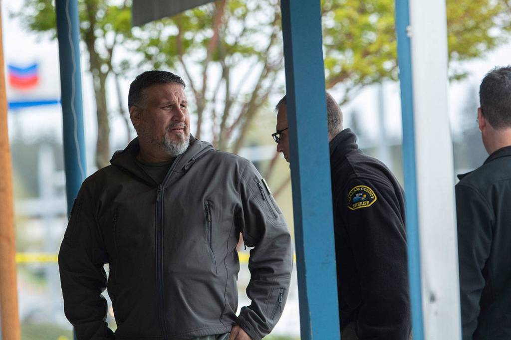 FREDS Guns owner Seth Larson talks to Clallam County Sheriffs detectives after someone drove a loader through his store and stole about 20-30 handguns. (Jesse Major/Peninsula Daily News)