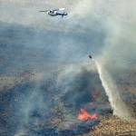 In this June 2018 photo, a helicopter uses a bucket to drop water on the Milepost 22 wildfire near Vantage, Washington. (AP Photo/Ted S. Warren, File)