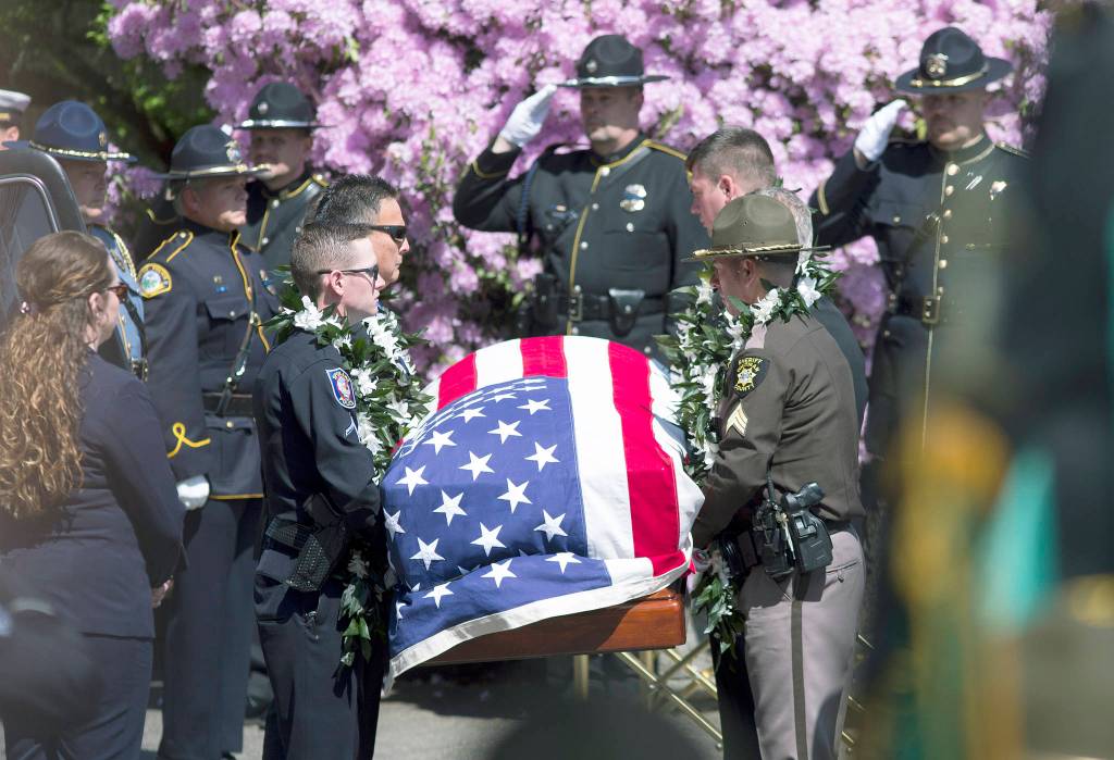 Beth Nakamura / The Oregonian                                An honor guard carries the casket of Cowlitz County Deputy Justin DeRosier as a procession makes its way to the Chiles Center at the University of Portland, where a memorial service took place Wednesday for the slain deputy in Portland, Oregon.