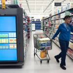 A customer pulls her shopping cart past an information kiosk at a Walmart Neighborhood Market on Wednesday in Levittown, New York. (AP Photo/Mark Lennihan)
