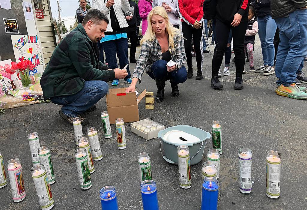Dozens of people gathered Thursday night to remember Jae An, 58, a mini mark clerk killed in a robbery on Broadway in Everett. (Caleb Hutton / The Herald)