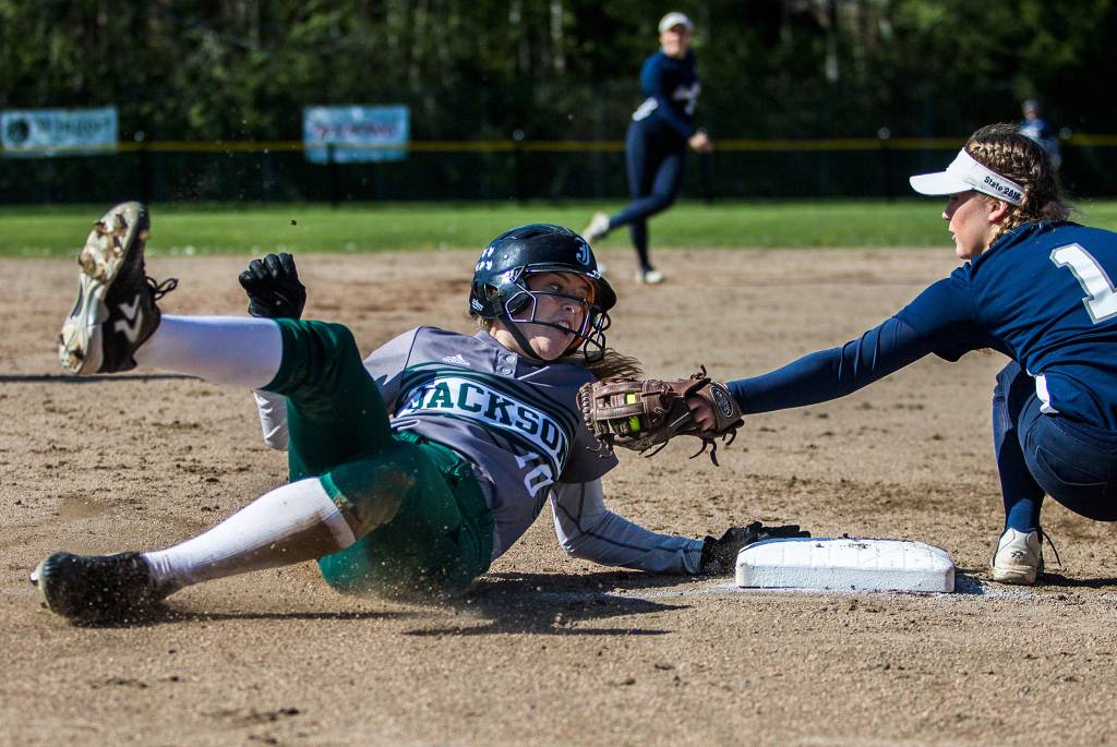 Jacksons Macy Tarbox safely slides into third base while Glacier Peaks Harlee Carpenter reaches out to tag her during the game at Henry M. Jackson High School on April 24 in Mill Creek. (Olivia Vanni / The Herald)