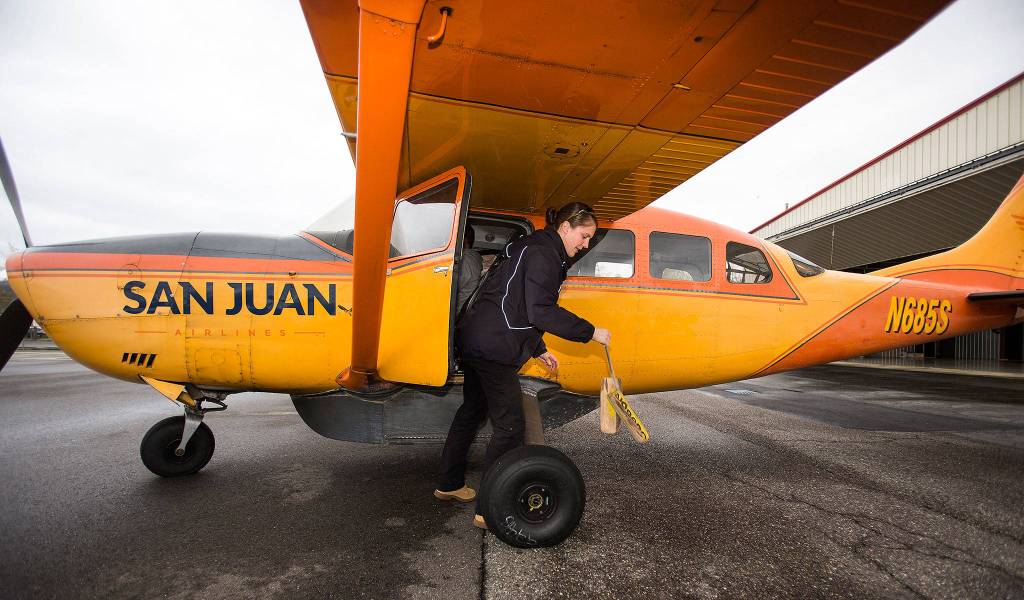 After loading passengers, San Juan Air pilot Rebecca Watson pulls chocks before piloting a Cessna 207 for an early morning flight out to the San Juan Islands from Bellingham International Airport on April 23 in Bellingham. (Andy Bronson / The Herald)